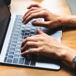 hands typing on laptop